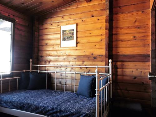 a bedroom with a bed in a log cabin at Pieter van Gent Winery & Vineyard in Eurunderee