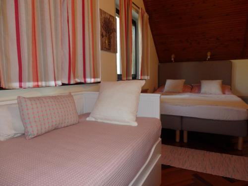 a bedroom with two beds and a window at Orgona Vendégház in Velence