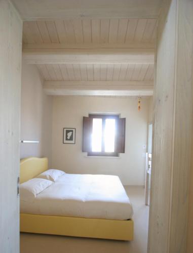 a bedroom with a bed and a window at Agriturismo Pozzuolo in Serrungarina