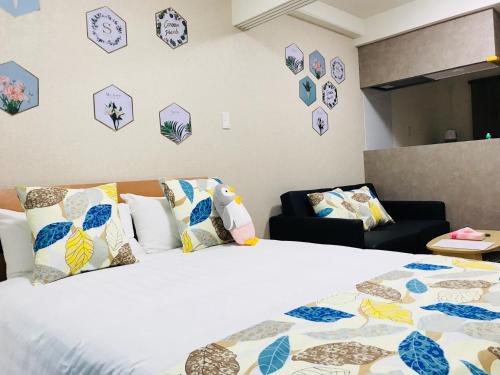 a bedroom with a bed with pillows and clocks on the wall at AFP Tennoji Apartment in Osaka