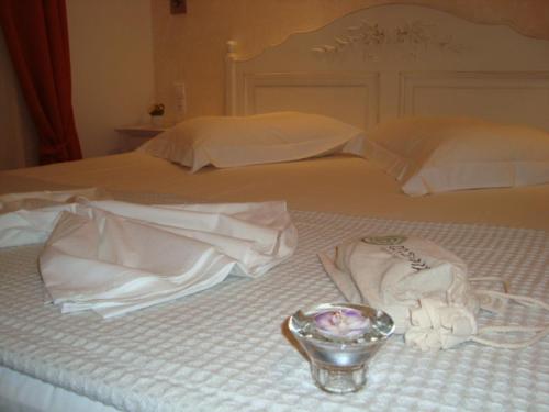 a bed with white towels and a bowl on it at Stampalia Luxury Studios in Astypalaia Town