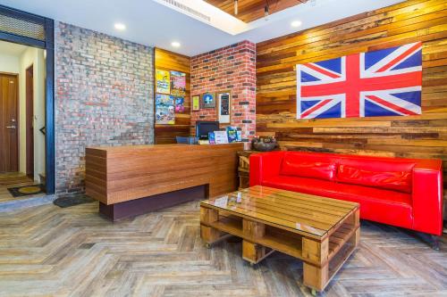 a red couch in a room with a flag on the wall at Treasury Hotel 301 in Kenting