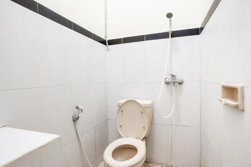 uma casa de banho com um WC e um chuveiro em RedDoorz near XT Square 2 em Yogyakarta