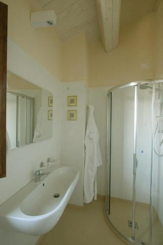 a white bathroom with a sink and a shower at Agriturismo Pozzuolo in Serrungarina