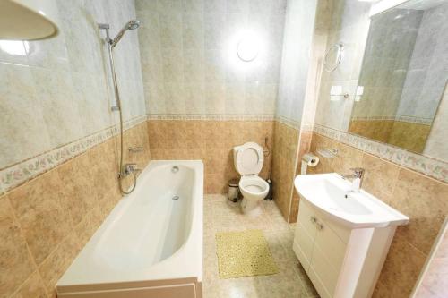 een badkamer met een bad, een toilet en een wastafel bij Roof top terrace maisonette in Plovdiv