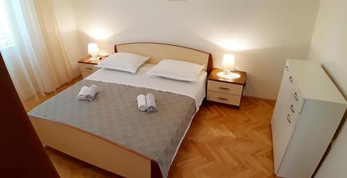 a bedroom with a bed with two slippers on it at Makarska Best Buy Apartments in Makarska