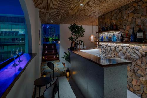 - un bar dans une pièce dotée d'un mur en pierre dans l'établissement Silverland Min Hotel, à Hô-Chi-Minh-Ville