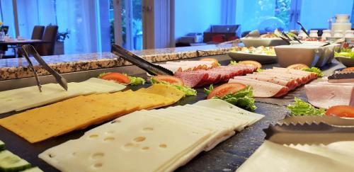 - un buffet de fromages et de viandes sur une table dans l'établissement Hotel Mingarden, à Düsseldorf