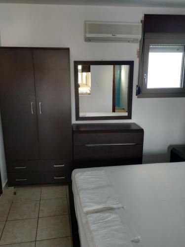 a small bedroom with a bed and a window at Mavroforos Hotel in Agios Nikolaos