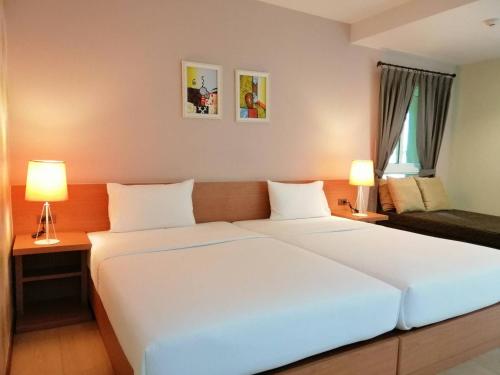 a large white bed in a room with two lamps at U Tiny Boutique Hotel Suvarnabhumi Bangkok - SHA Plus in Lat Krabang