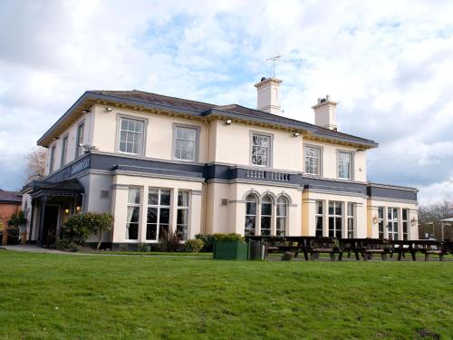 a large house with a picnic table in front of it at The Cheshire Cat by Innkeeper's Collection in Chester