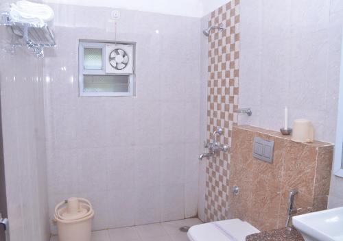 a bathroom with a shower with a toilet and a window at MPT Tourist Motel, Dodi in Dodi