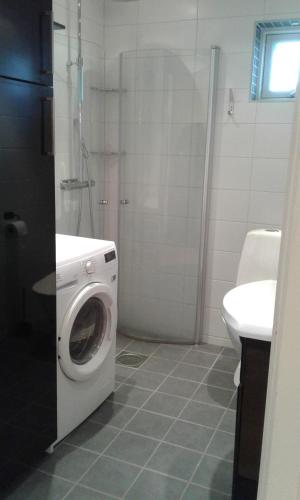 a bathroom with a washing machine and a sink at Stuga i Gamla-köpstad in TrÃ¤slÃ¶vslÃ¤ge