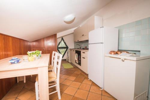 a kitchen with a table and a white refrigerator at Belvedere di Gloria in Tramonti