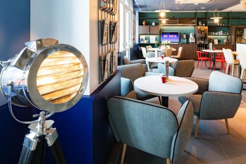 a restaurant with a mirror and chairs and tables at ibis Saint Malo Plage in Saint Malo