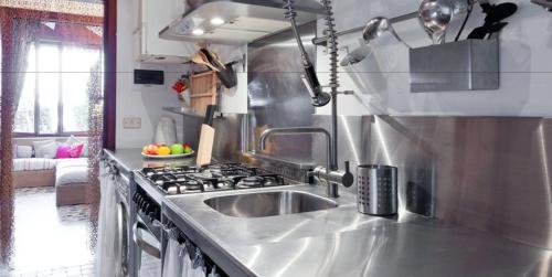 a kitchen with a sink and a stove at Jesolo sea front garden apartment in Lido di Jesolo