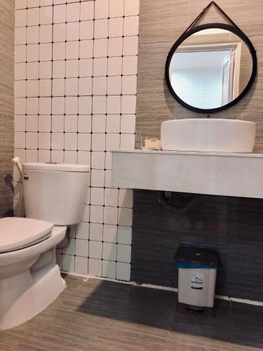 a bathroom with a toilet and a mirror at Sele House in Ha Tien