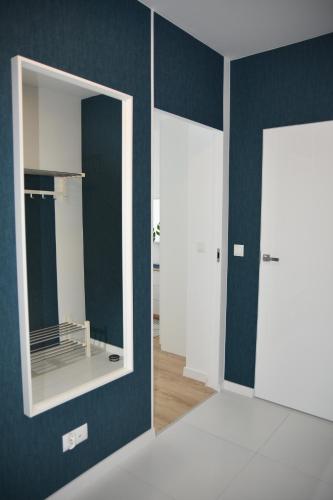 Pokój z 2 otwartymi drzwiami i lustrem w obiekcie Natura Apartament w mieście Gdynia