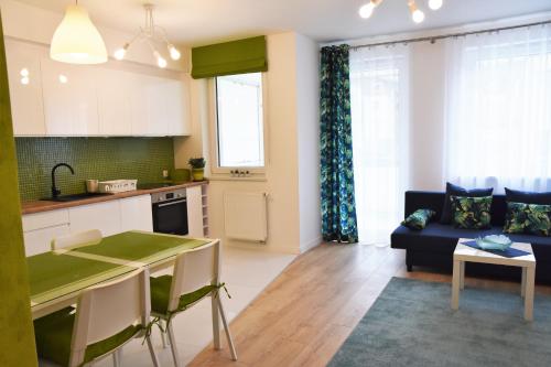 kuchnia i salon z kanapą i stołem w obiekcie Natura Apartament w mieście Gdynia