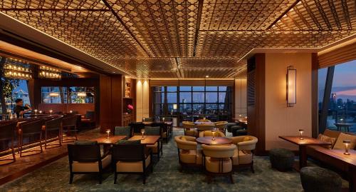 a restaurant with tables and chairs and a bar at Hyatt Regency Bangkok Sukhumvit in Bangkok