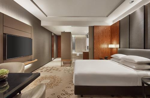 a hotel room with a bed and a television at Hyatt Regency Bangkok Sukhumvit in Bangkok