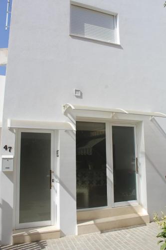 un edificio blanco con puertas correderas de cristal. en Apartamentos Angelita Plaza Beach, en Málaga