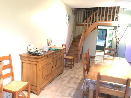 a room with a table and chairs and a staircase at Domaine BORCHAMPS. in Saint-Nizier-sous-Charlieu