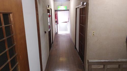 an empty hallway with a door and a hallwayngthngthngthngthngthngthngth at Walking Pilgrimage Hotel Tokiwa Ryokan in Ōzu