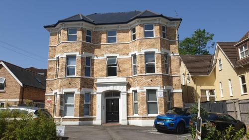 a brick house with a blue car parked in front of it at Superb 2 beds 2 baths New Apartment w/ Garden+Patio in Bournemouth