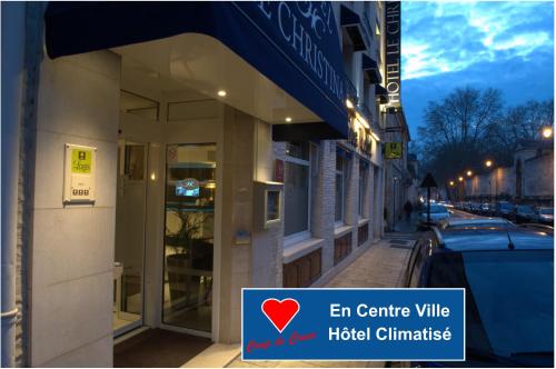 a building with an open door on a city street at Logis - Le Christina in Bourges