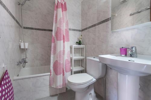 a bathroom with a toilet and a sink and a shower curtain at Lets Holidays Apartment Tossa Near Beach 2 in Tossa de Mar