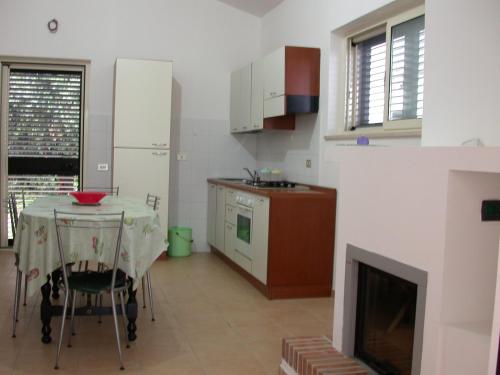 eine Küche mit einem Tisch und eine Küche mit einem Kamin in der Unterkunft Casa Vacanze Agriturismo BioMele in Policoro