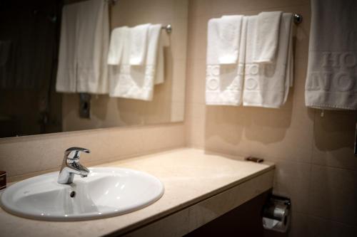 a bathroom with a sink and a mirror and towels at Panorama Hotel - Free EV Charging Station in Varna City