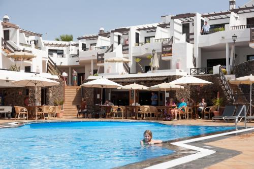 a girl swimming in a swimming pool in a hotel at Club Oceano in Puerto del Carmen