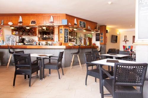 a restaurant with tables and chairs and a bar at Club Oceano in Puerto del Carmen