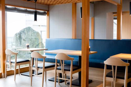 a dining room with two tables and stools at Hotel Wing International Asahikawa Ekimae in Asahikawa