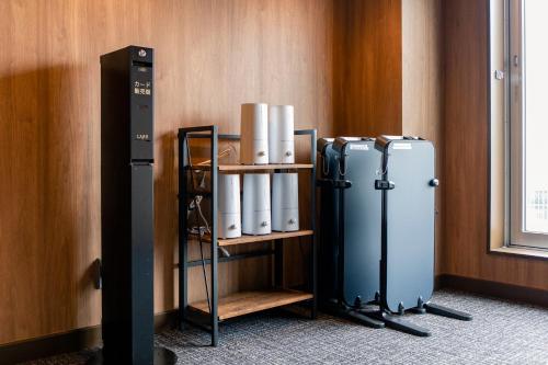a room with two refrigerators and a shelf with books at Hotel Wing International Asahikawa Ekimae in Asahikawa