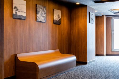 a wooden wall with a bench in a room at Hotel Wing International Asahikawa Ekimae in Asahikawa