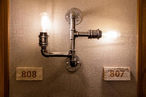 a light attached to a wall with two signs at Hotel Wing International Asahikawa Ekimae in Asahikawa
