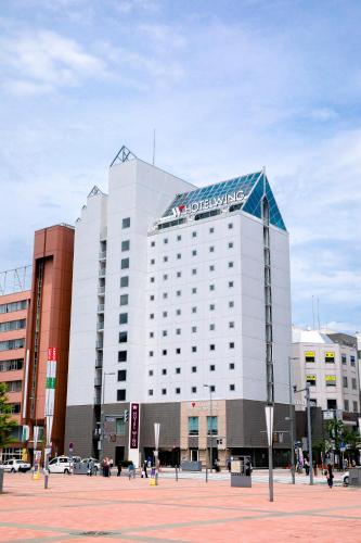 a building with a sign on the top of it at Hotel Wing International Asahikawa Ekimae in Asahikawa