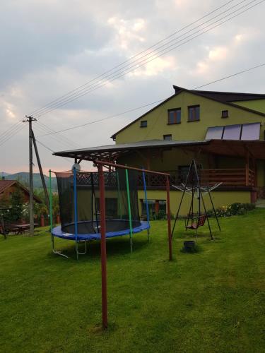 a playground in a yard next to a house at sunset view house in Stryszawa