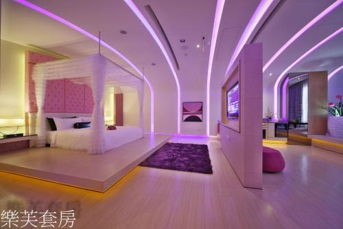a bedroom with a bed in a room with purple lighting at Doule Motel in Taichung