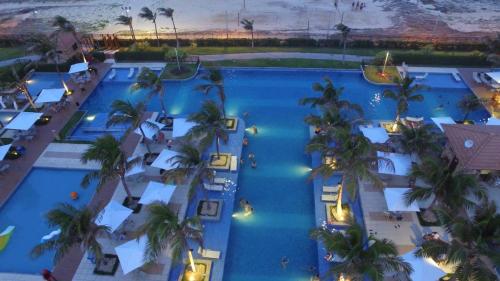 an overhead view of a resort pool with palm trees at Mandara Lanai in Aquiraz