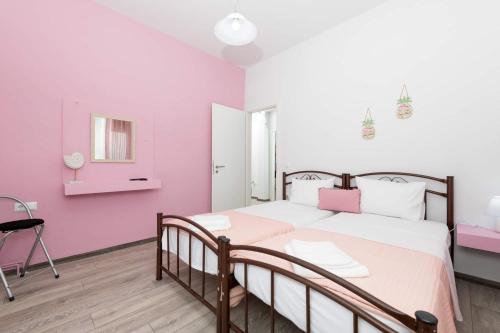 a bedroom with a large bed with pink walls at Anastasia's Apartment in Limenas