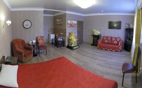 a living room with chairs and a couch and a tv at Міні-готель Пекін in Mykolaiv