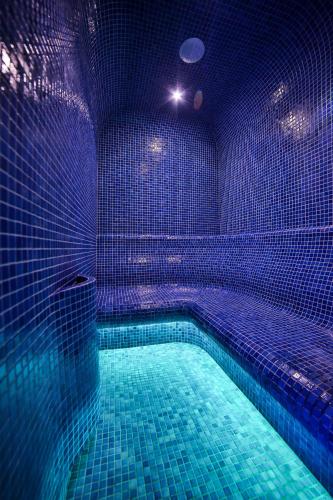 a swimming pool with blue lights in a room at Grand Podhale Resort&Spa Zakopane - Jacuzzi - Sauna fińska i Łaźnia parowa - Widok na Tatry in Zakopane