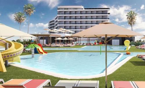 ein Swimmingpool mit Stühlen und Sonnenschirmen neben einem Hotel in der Unterkunft AZ Hôtels Zephyr in Mostaganem