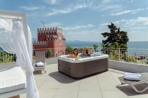a woman in a bath tub on a balcony at Hotel Villa Garuti in Padenghe sul Garda