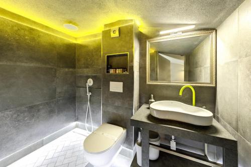 a bathroom with a sink and a toilet and a mirror at Barocco Wave Hotel in Skala Potamias