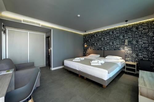 a bedroom with a bed and a brick wall at Barocco Wave Hotel in Skala Potamias
